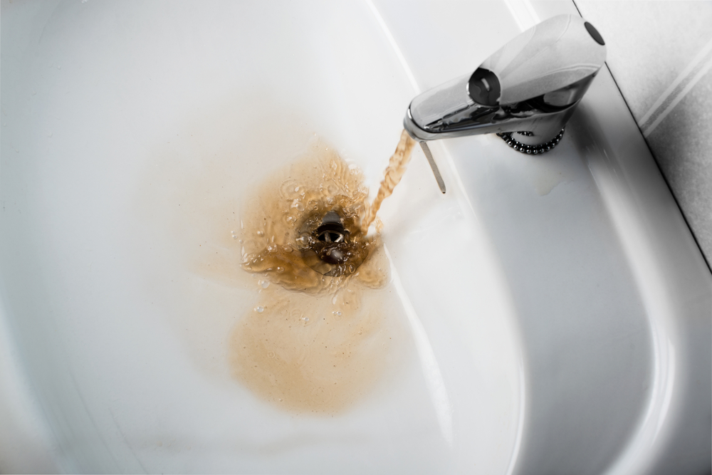 Rusty water running into a white sink